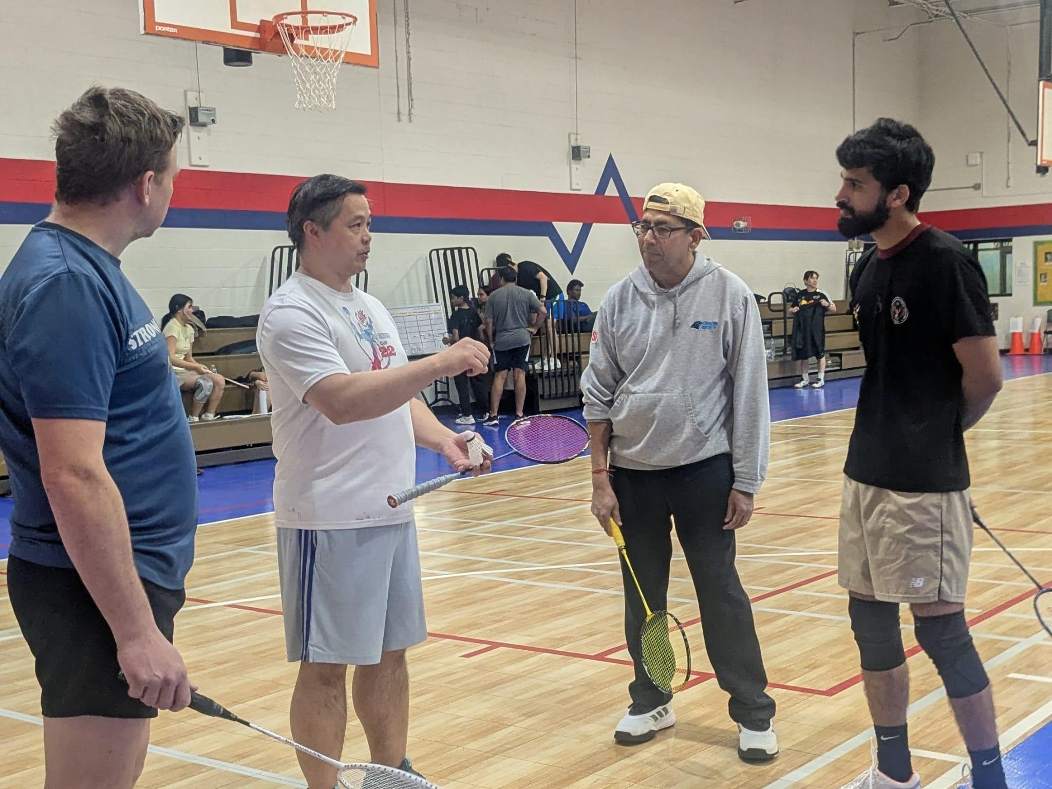 Greensboro Badminton Club players listening during an on-court training session